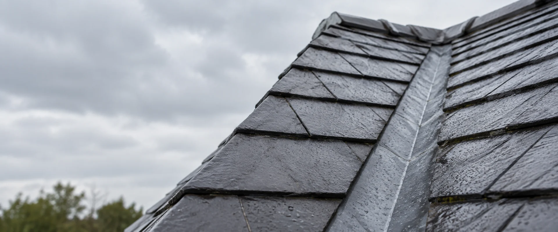 Illustrative rain-wet roof valley between slate roof slopes.